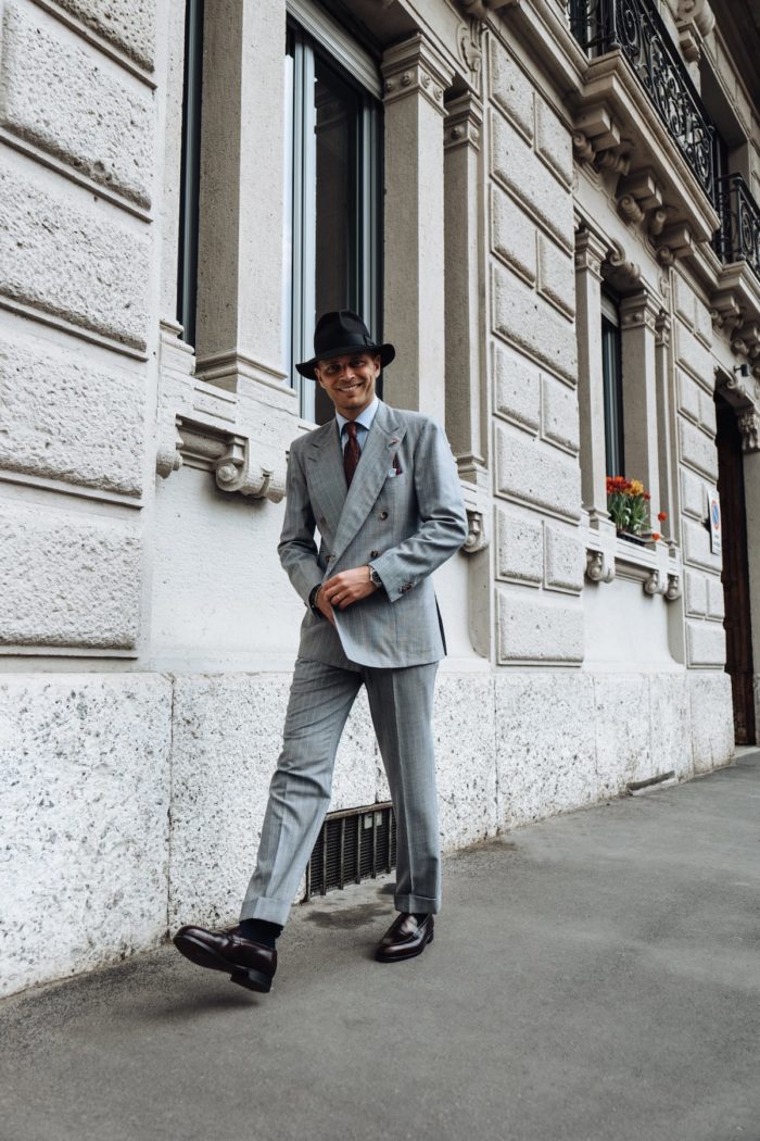 homme marchant rue costume croisé gris mocassins chapeau