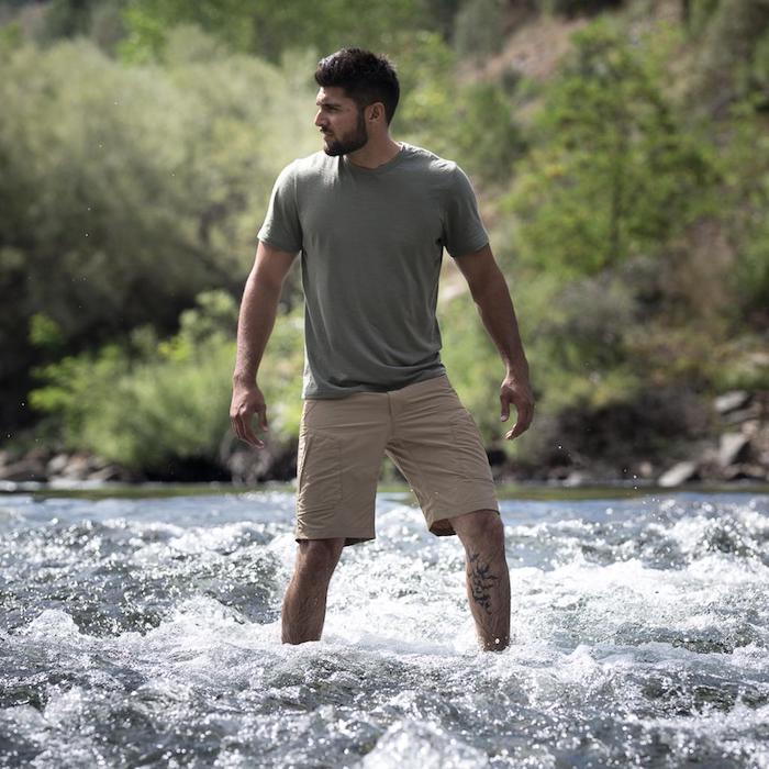 Homme en short et en tee-shirt debout dans une rivière