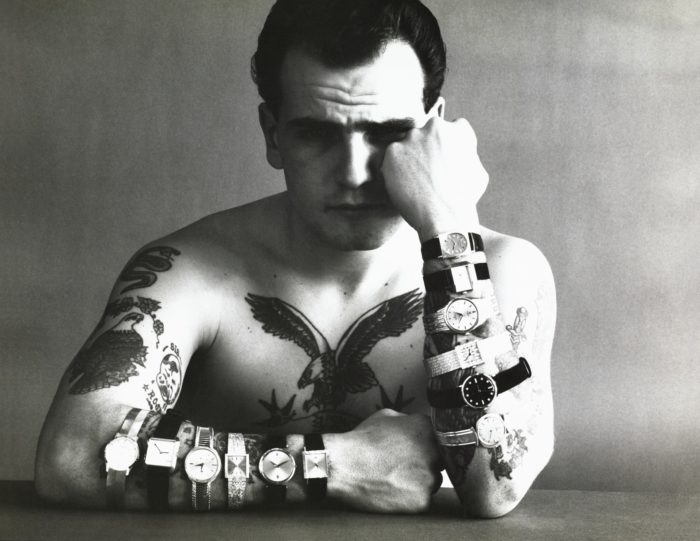 Homme tatoué avec une dizaine de montres aux poignets