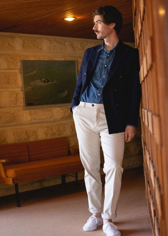 Homme en blazer bleue, chemise indigo et pantalon blanc.