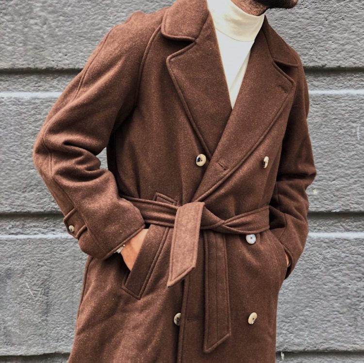 manteau croisé marron de bonne facture porté avec un col roulé blanc cassé